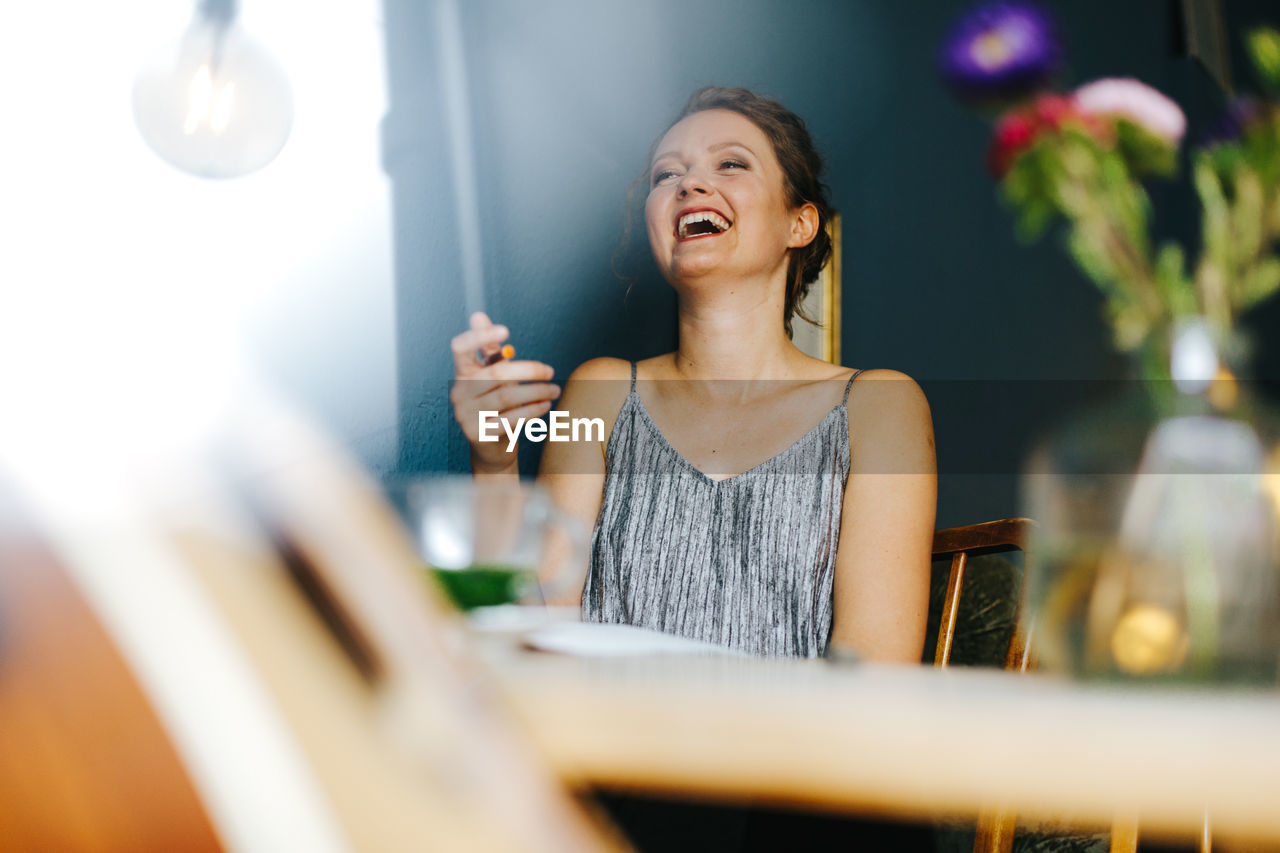 Smiling young woman sitting at cafe