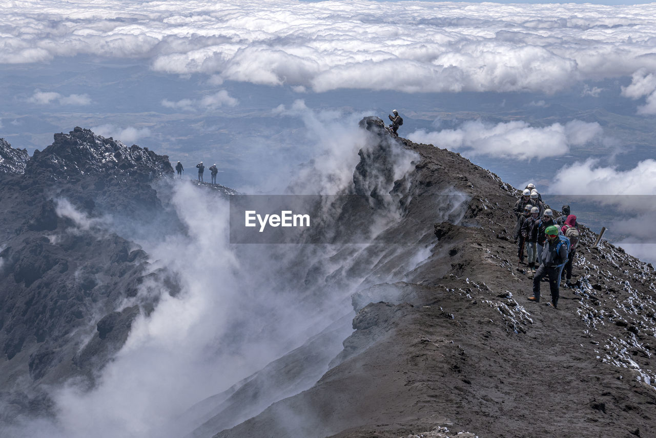 PEOPLE ON MOUNTAIN AGAINST SKY