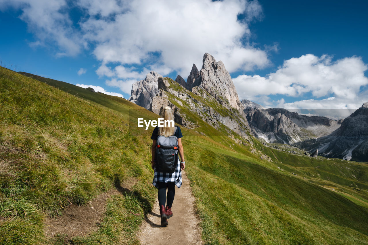 REAR VIEW OF WOMAN WALKING ON MOUNTAIN