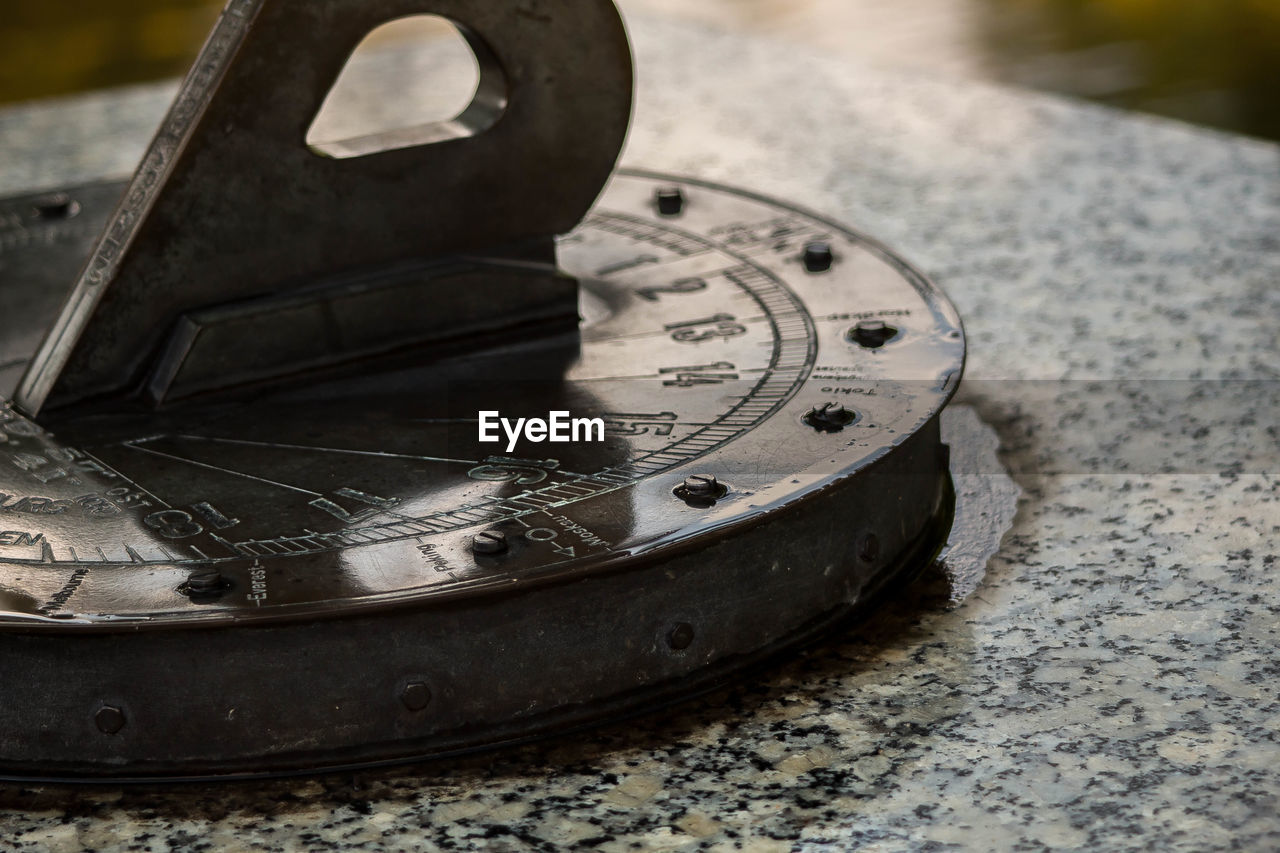 CLOSE-UP OF CLOCK ON METAL TABLE
