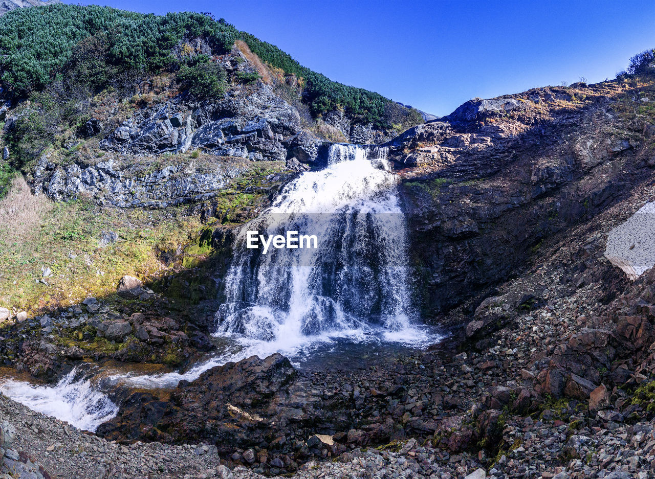 Scenic view of waterfall against sky