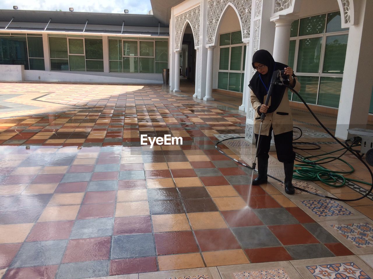 FULL LENGTH OF WOMAN STANDING ON FLOOR AGAINST BUILDING