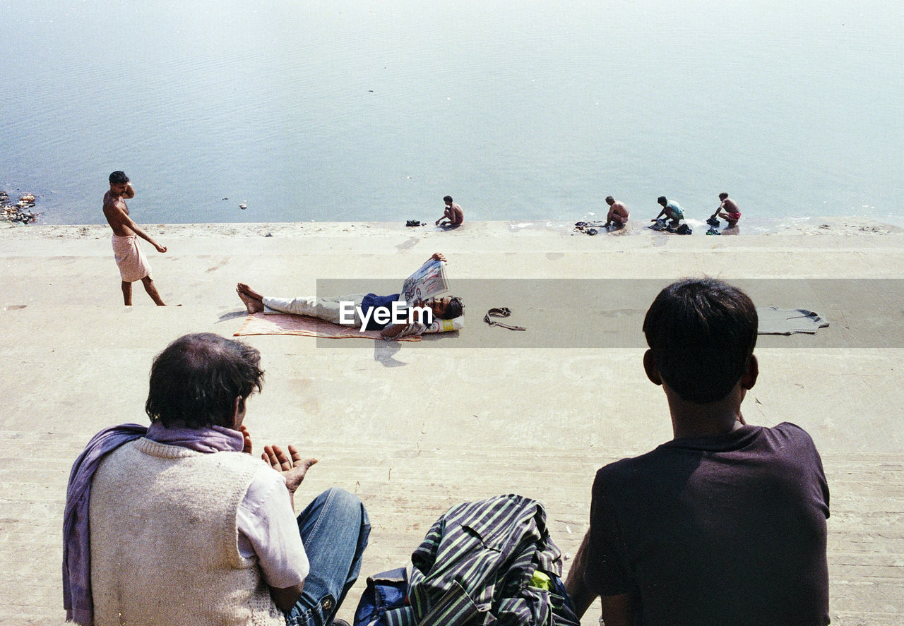 WOMAN SITTING ON SHORE