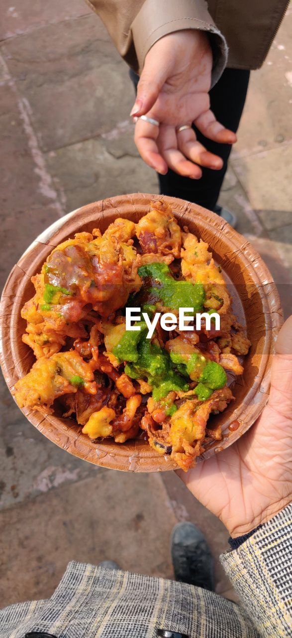 High angle view of man holding food on table