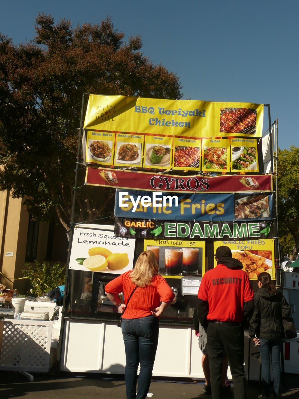 REAR VIEW OF PEOPLE STANDING BY TEXT ON WALL