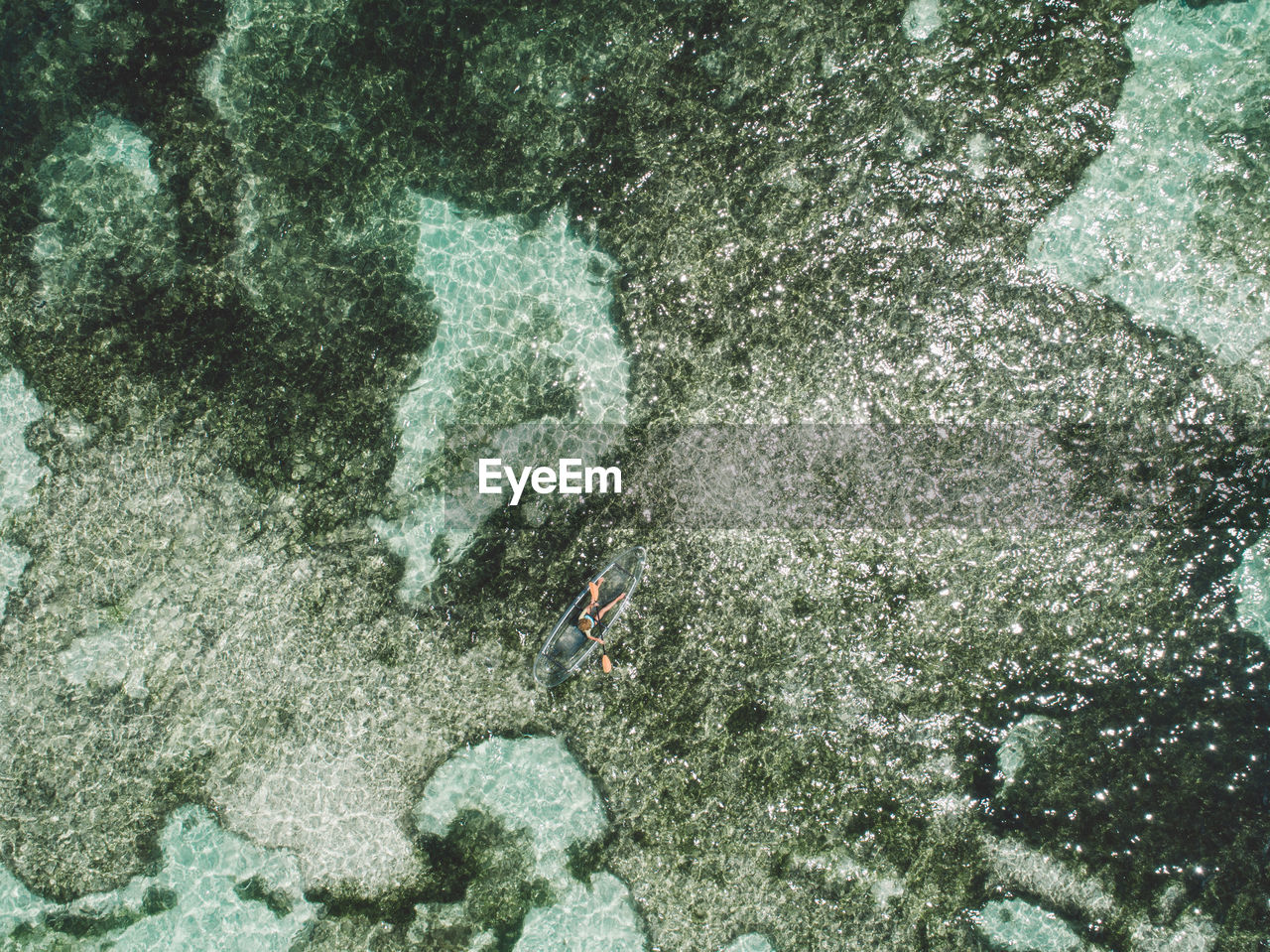 Aerial view of woman in inflatable boat on sea