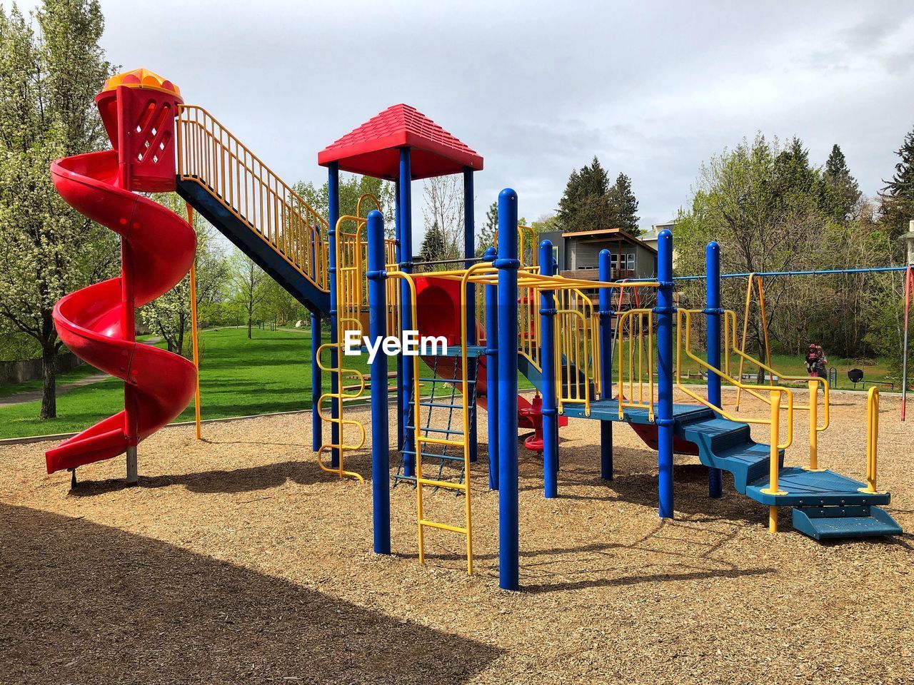 EMPTY CHAIRS IN PLAYGROUND AGAINST SKY