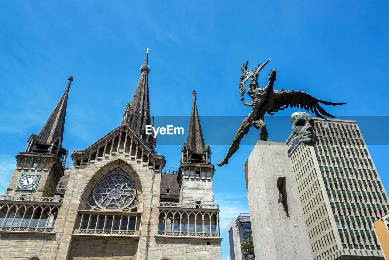 Low angle view of monument and manizales cathedral against sky