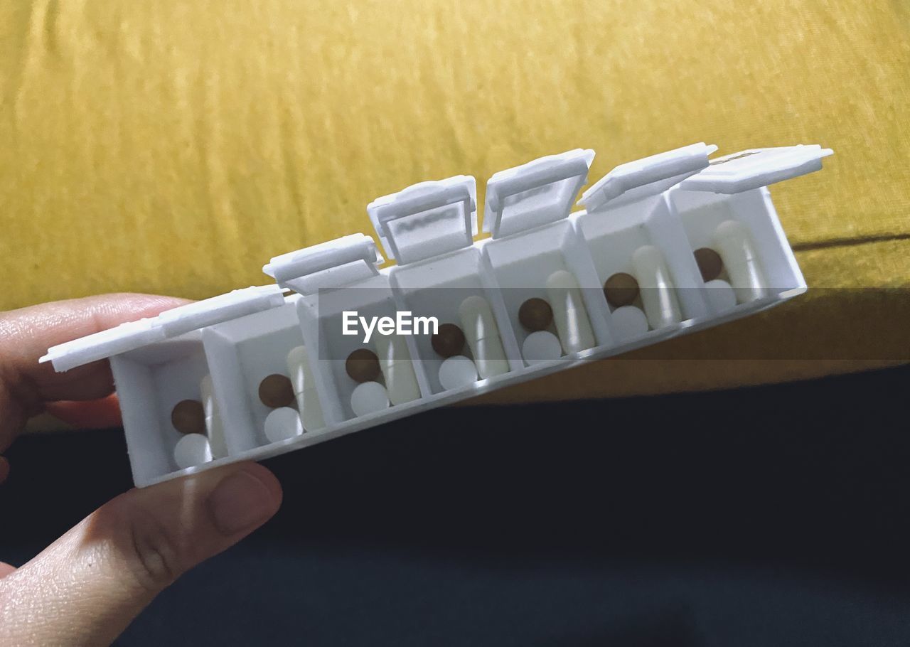 HIGH ANGLE VIEW OF PERSON HAND HOLDING WHITE