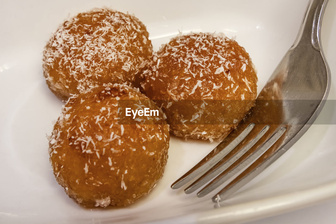 Close up kemalpasha dessert in white plate with grated coconut.