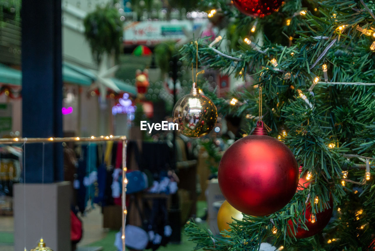 CLOSE-UP OF CHRISTMAS DECORATION HANGING ON TREE AT NIGHT