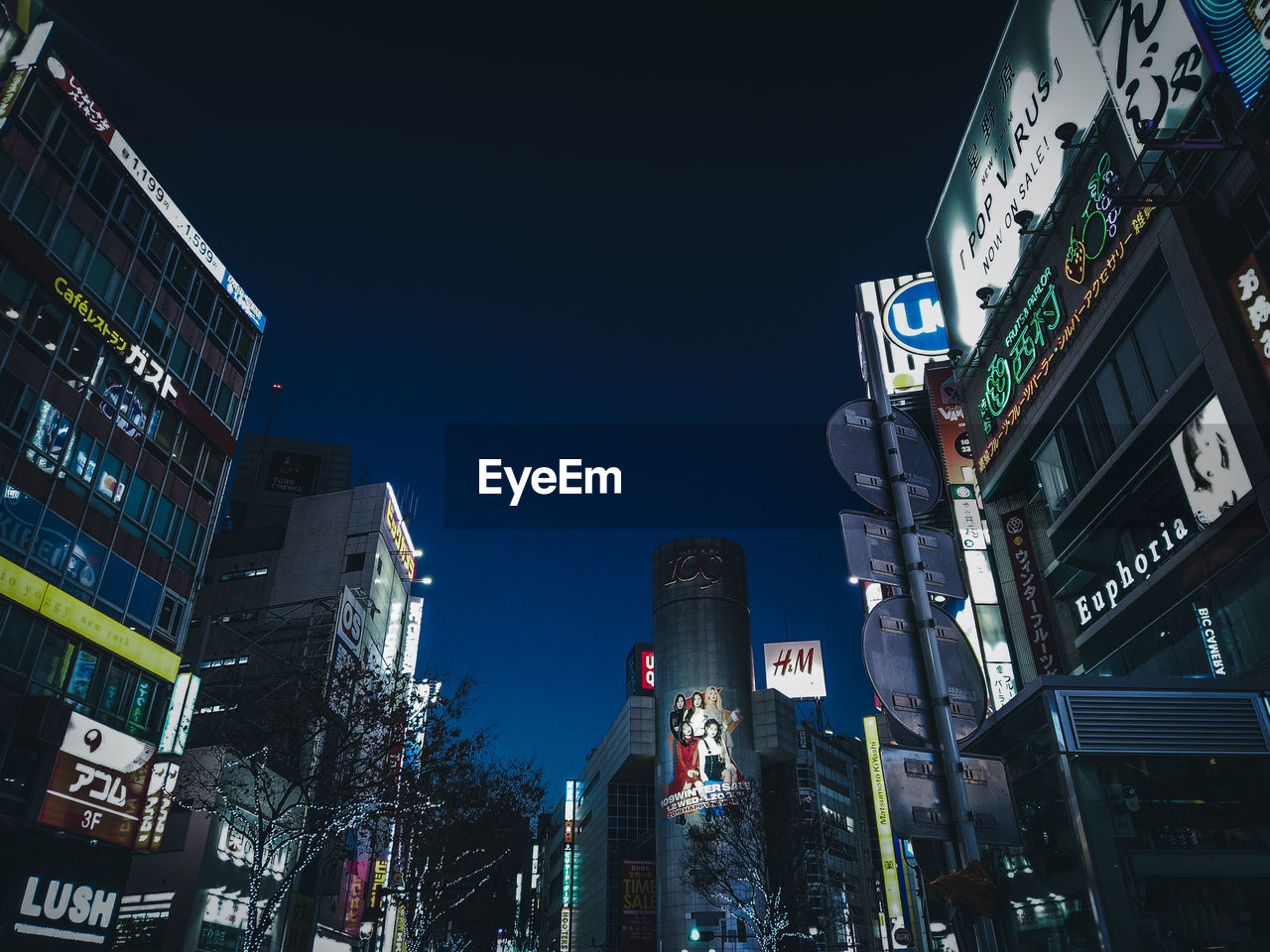 LOW ANGLE VIEW OF ILLUMINATED MODERN BUILDINGS AGAINST CLEAR SKY