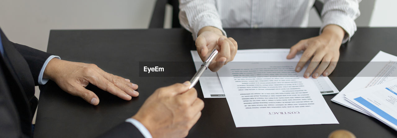 midsection of business colleagues working on table