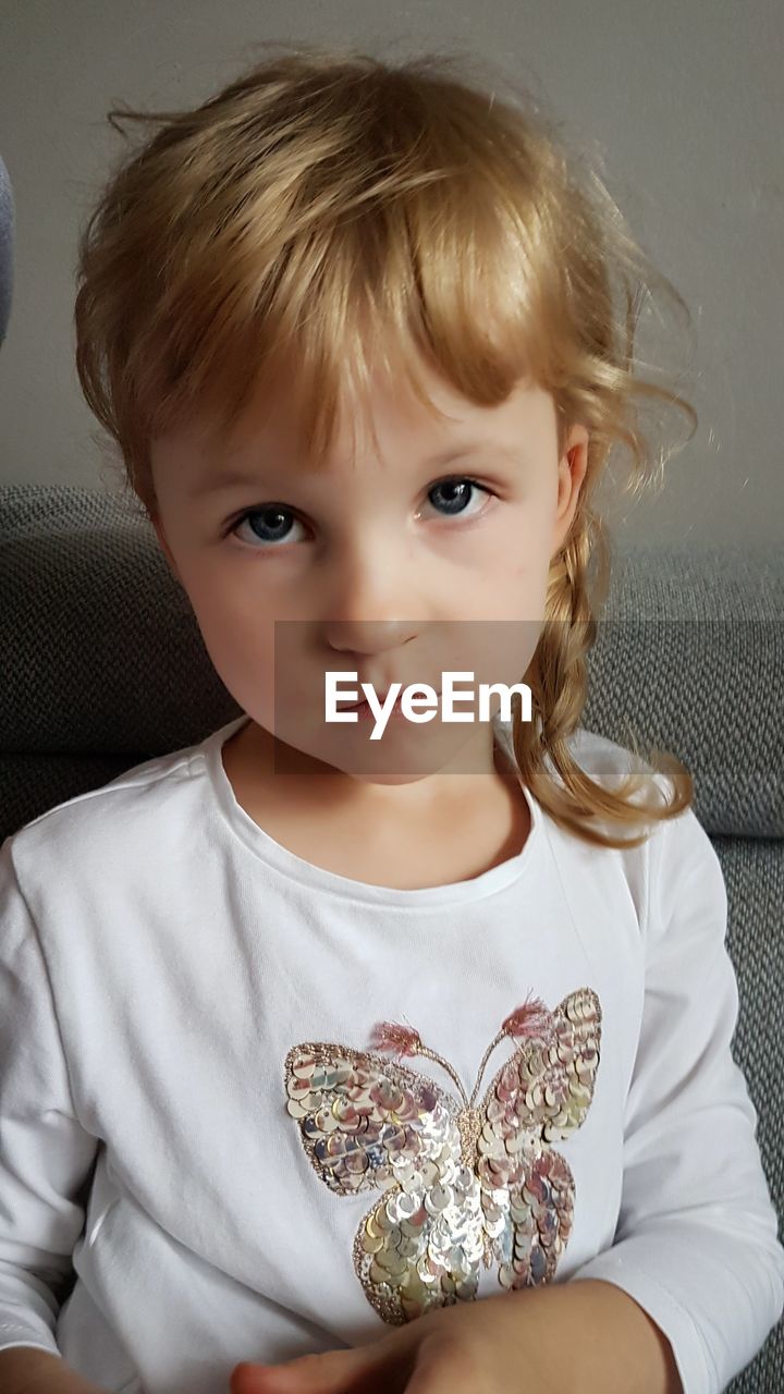 Portrait of cute girl sitting on sofa