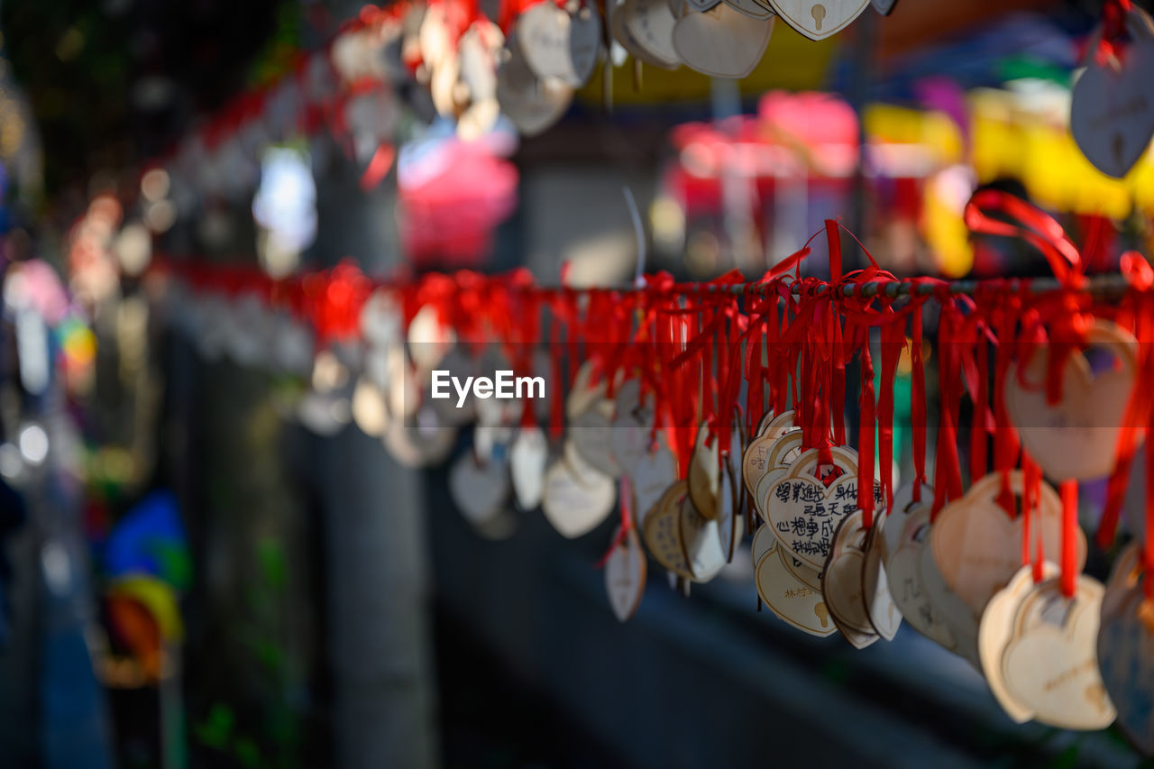 CLOSE-UP OF MULTI COLORED DECORATIONS HANGING IN MARKET STALL