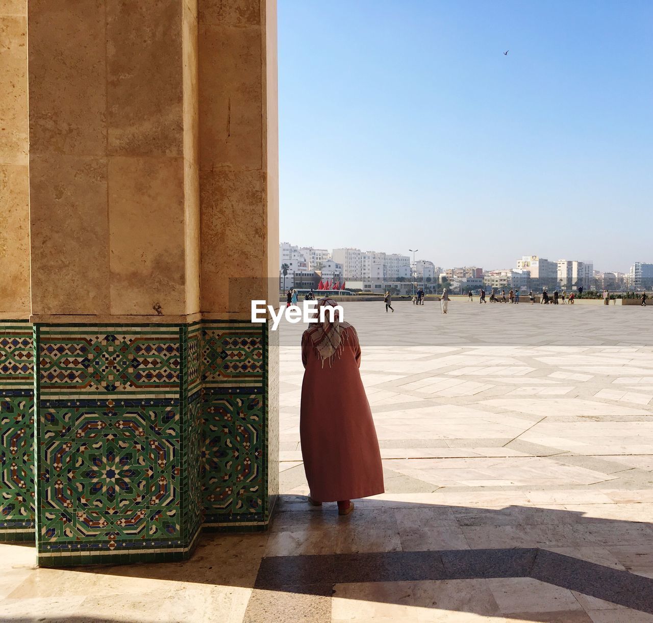 Rear view of woman standing at mosque against sky