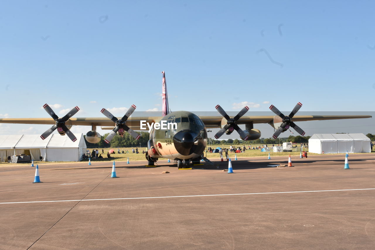 Airplane on airport runway against blue sky