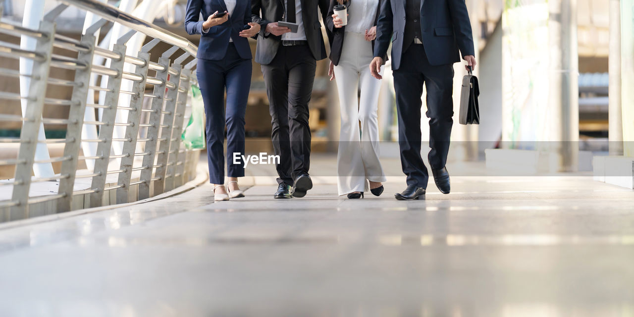 LOW SECTION OF PEOPLE WALKING ON CORRIDOR