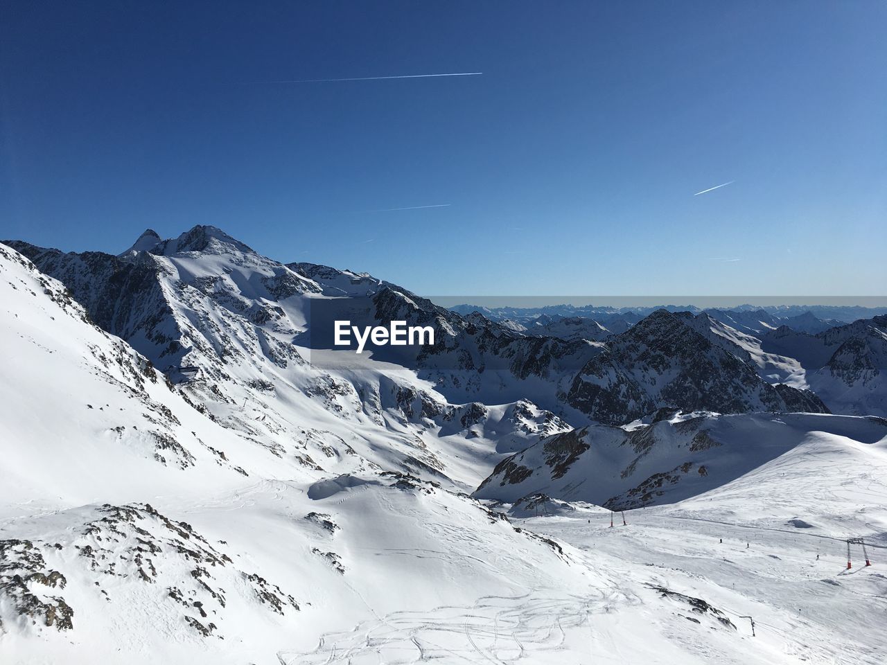 Scenic view of snowcapped mountains against blue sky