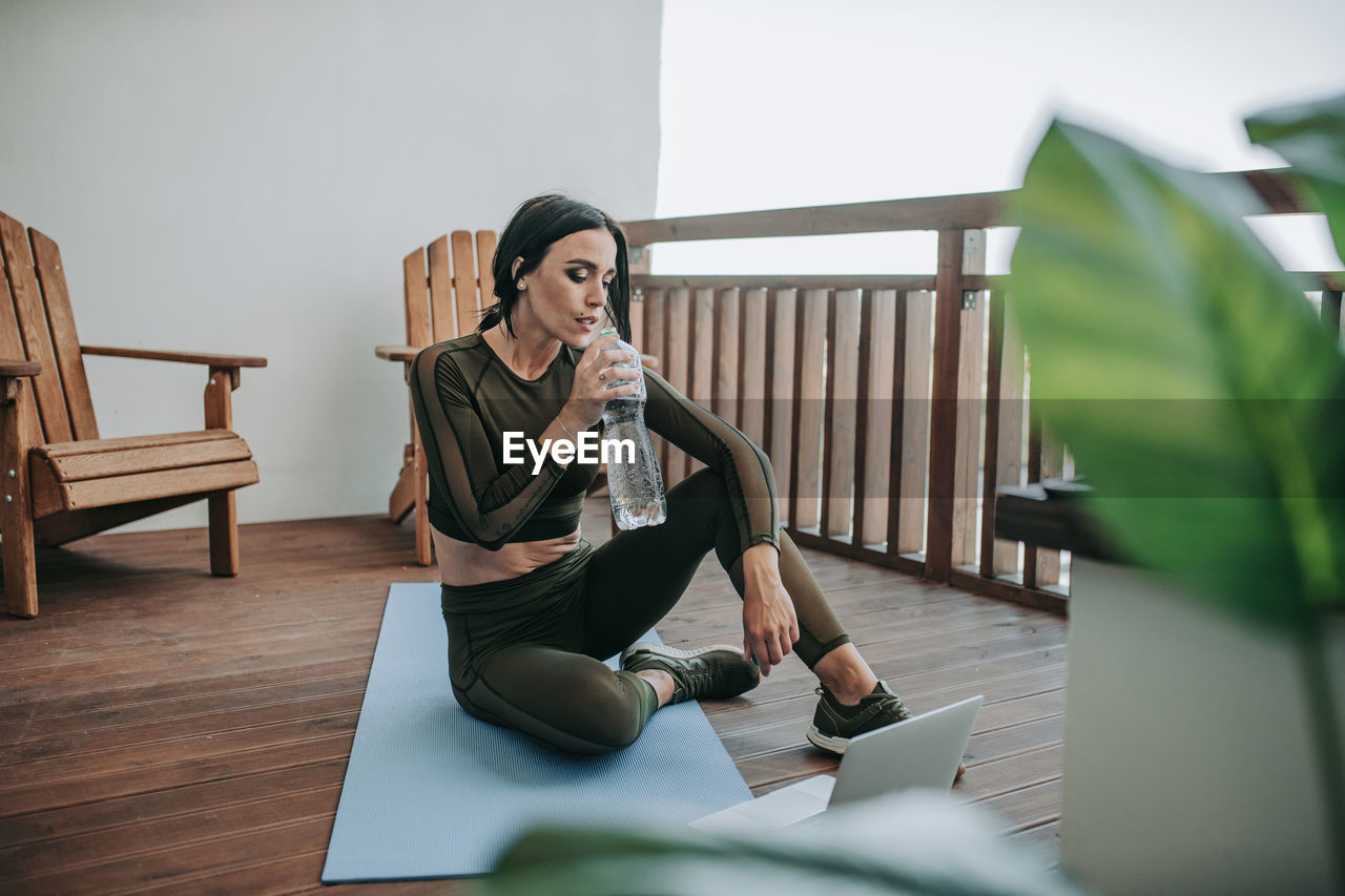 Woman using phone while sitting on table