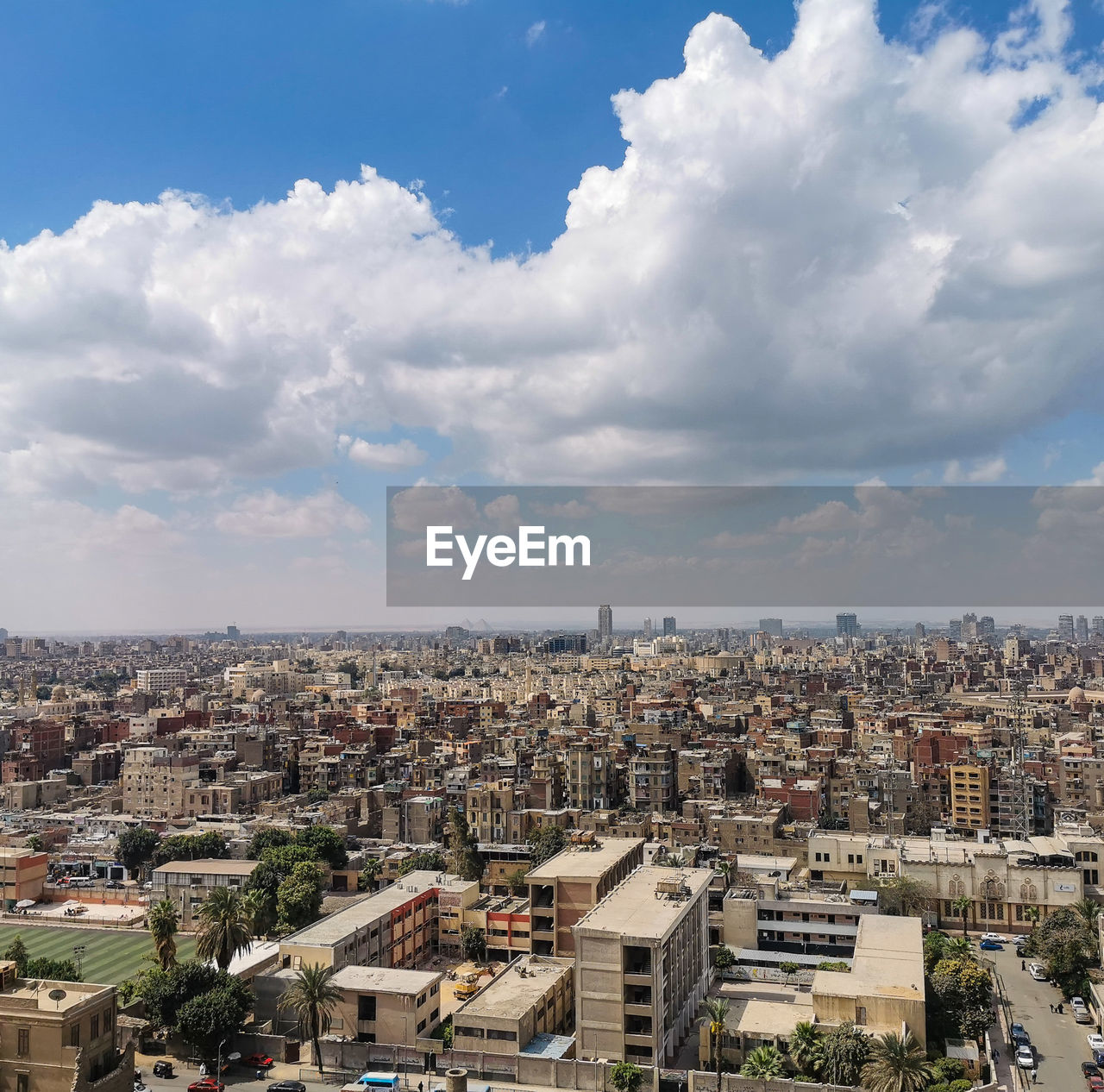 High angle view of cairo townscape against sky from citadel of saladin, pyramid of giza in distance