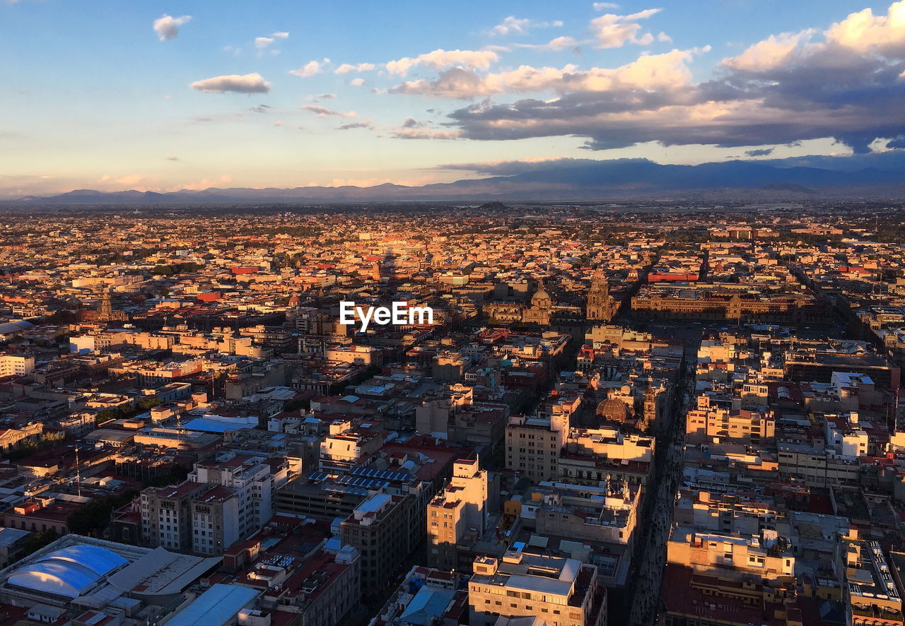 HIGH ANGLE SHOT OF TOWNSCAPE AGAINST SKY DURING SUNSET