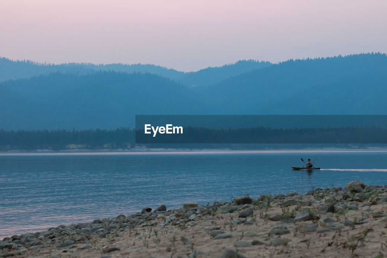 Scenic view of sea and mountains against sky