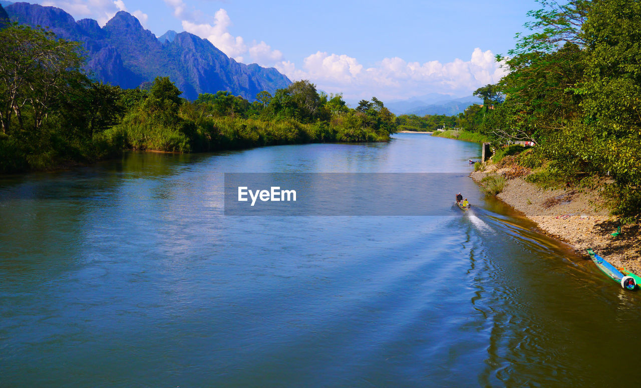 Scenic view of river amidst trees against sky