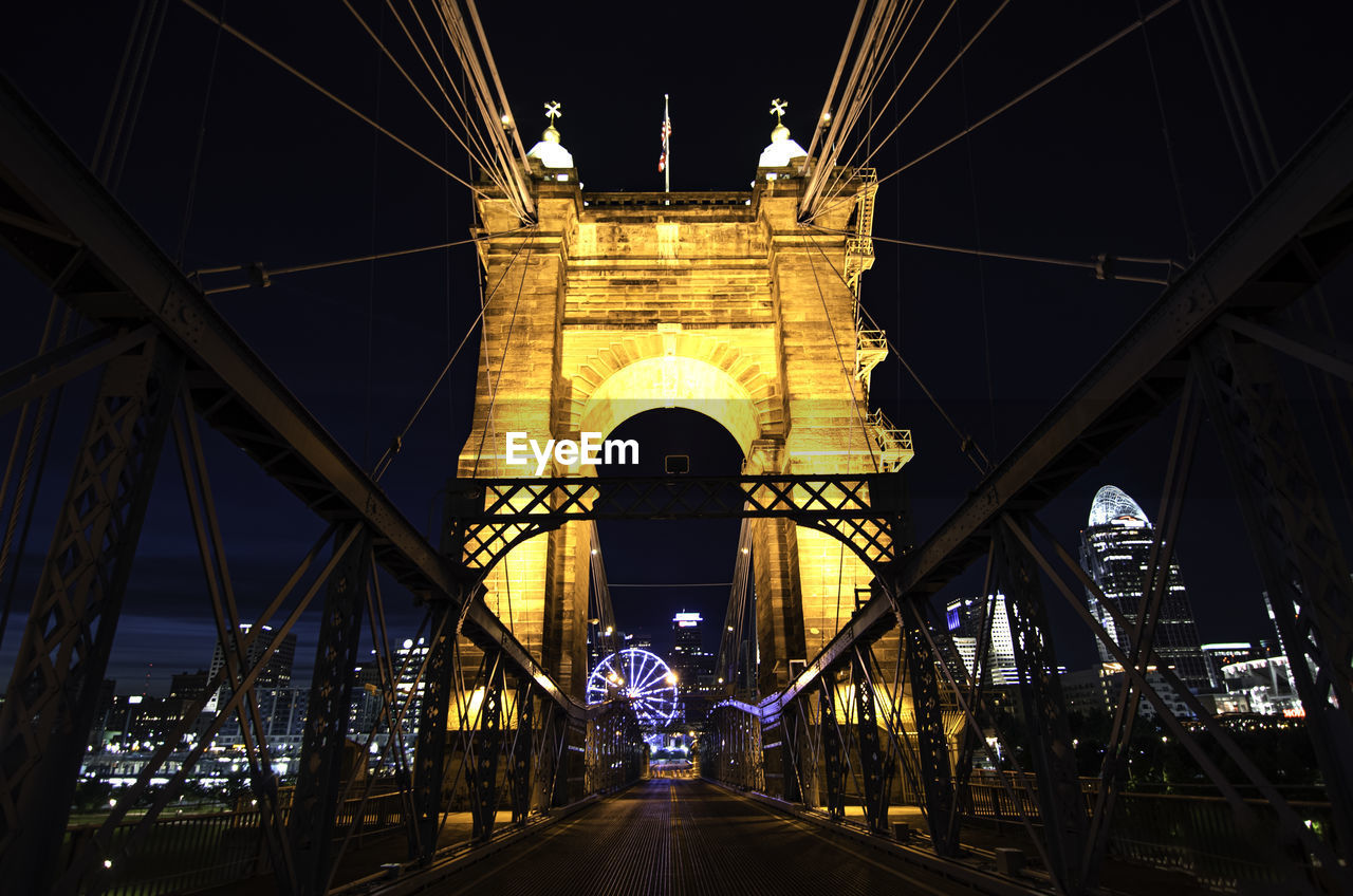 Illuminated bridge in city at night