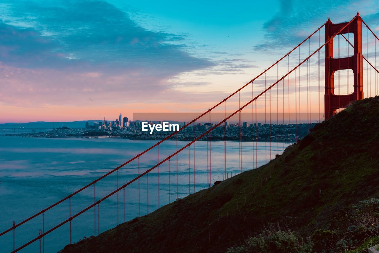 View of suspension bridge against cloudy sky