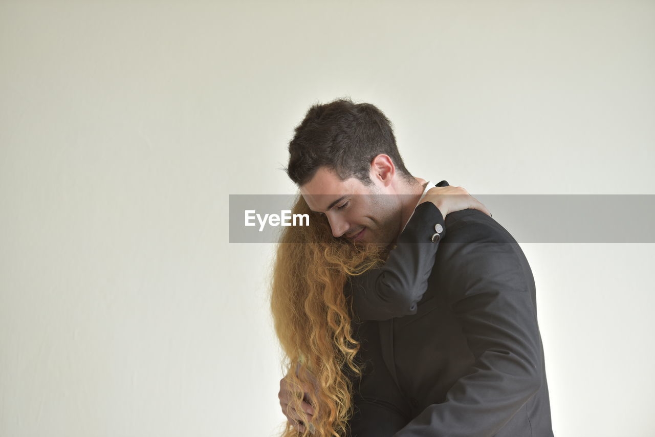 MAN LOOKING AWAY AGAINST WHITE BACKGROUND