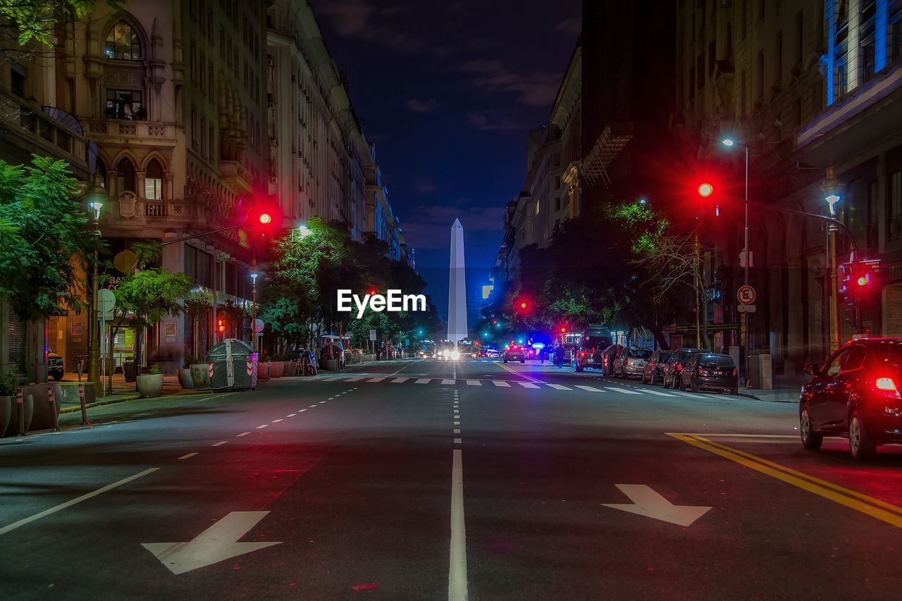 Road leading towards obelisco de buenos aires in city at night