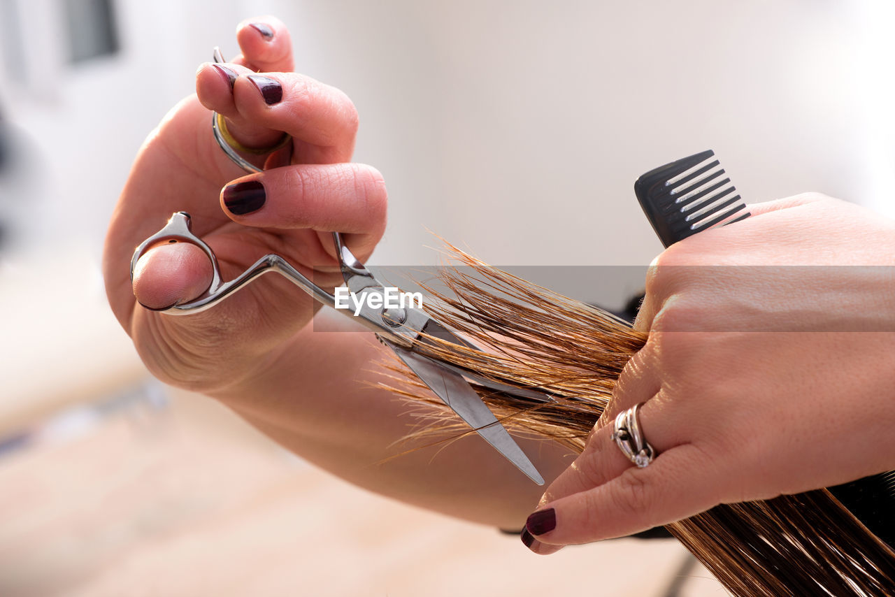 Cropped image of hairdresser with customer in salon