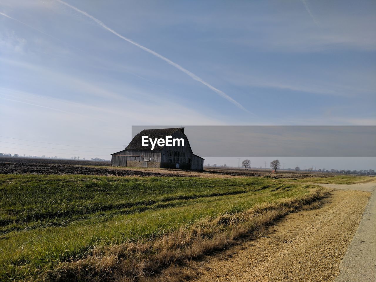 Barn on field against sky