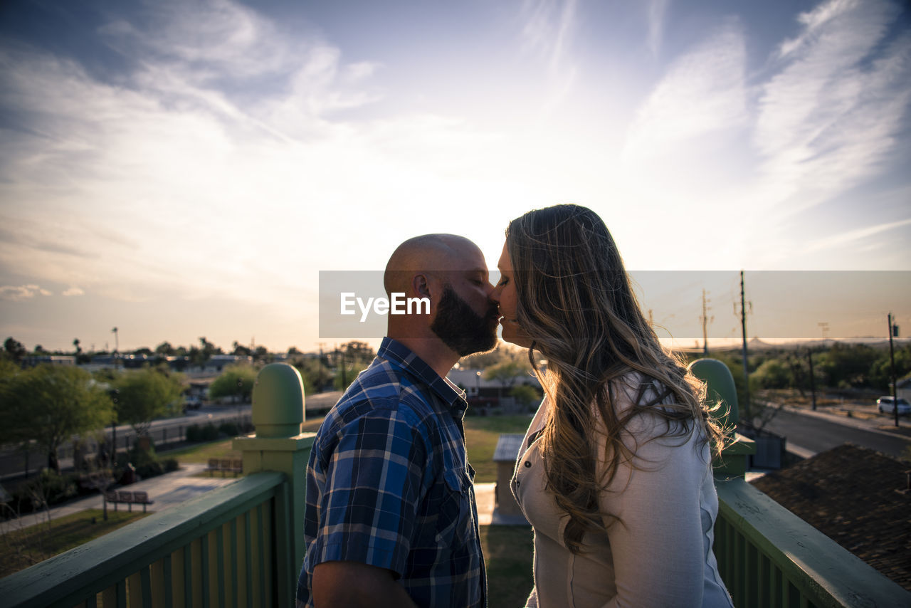 Couple kissing against sky