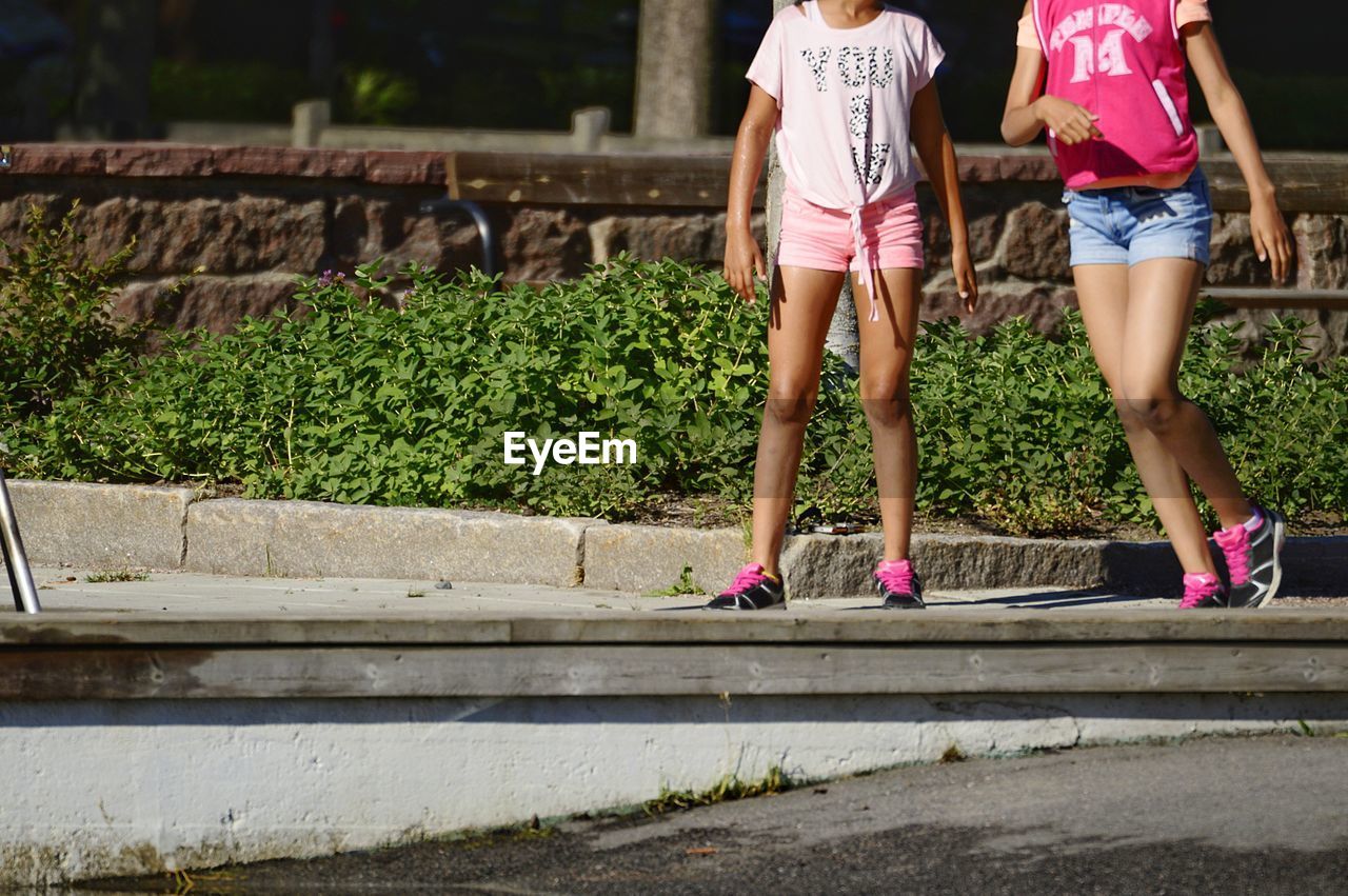 Low section of women walking on footpath