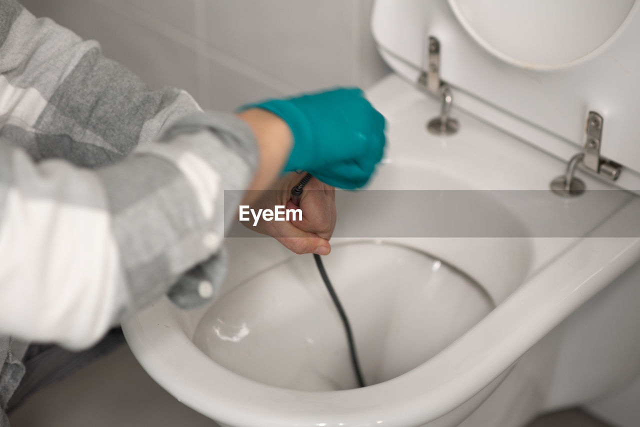 Man cleaning overflowing broken toilet. clogged toilet.