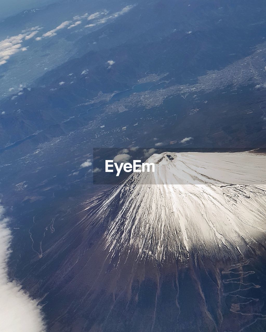 Aerial view of snowcapped mountain during sunny day