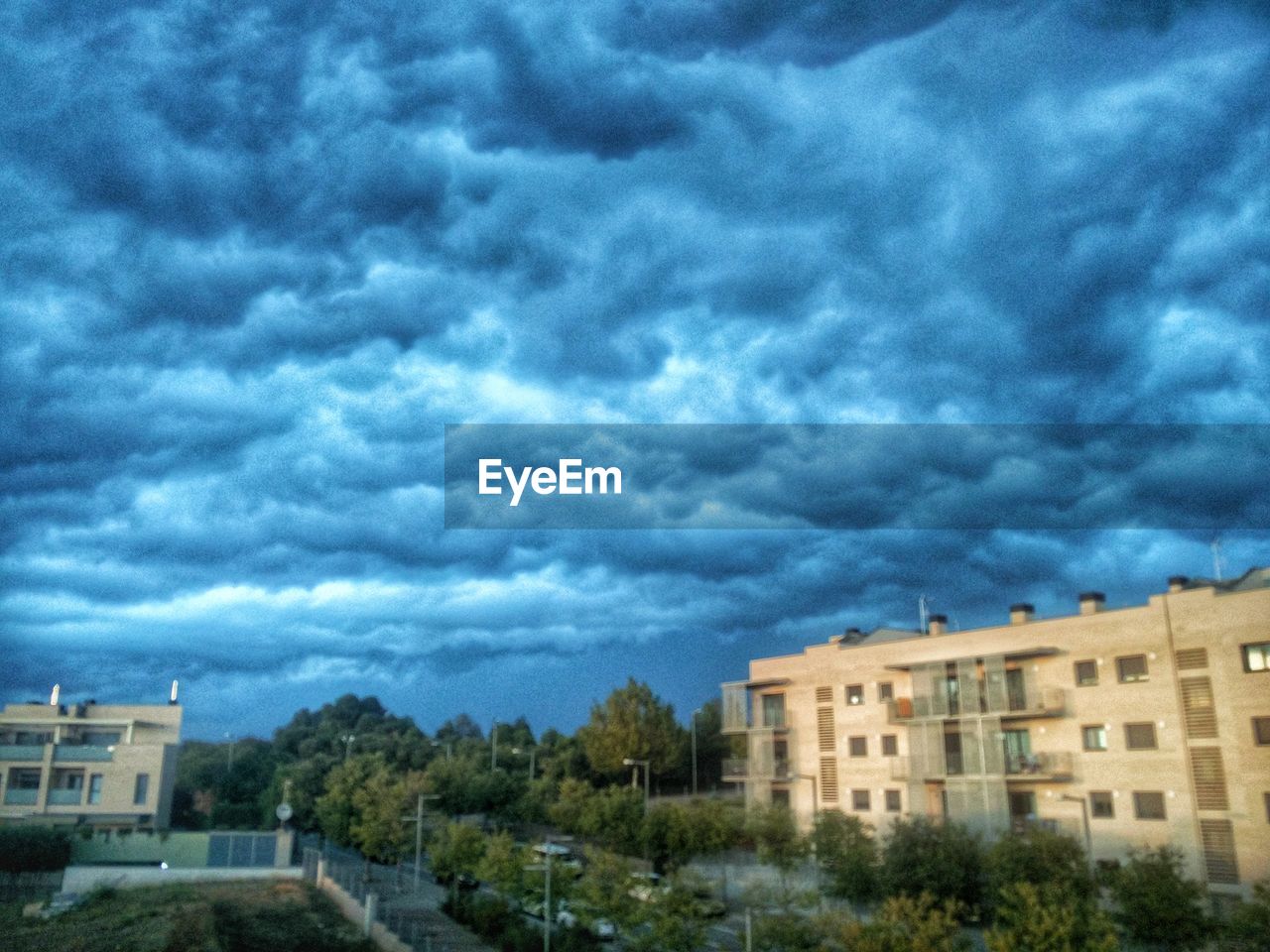 VIEW OF BUILDINGS AGAINST CLOUDY SKY