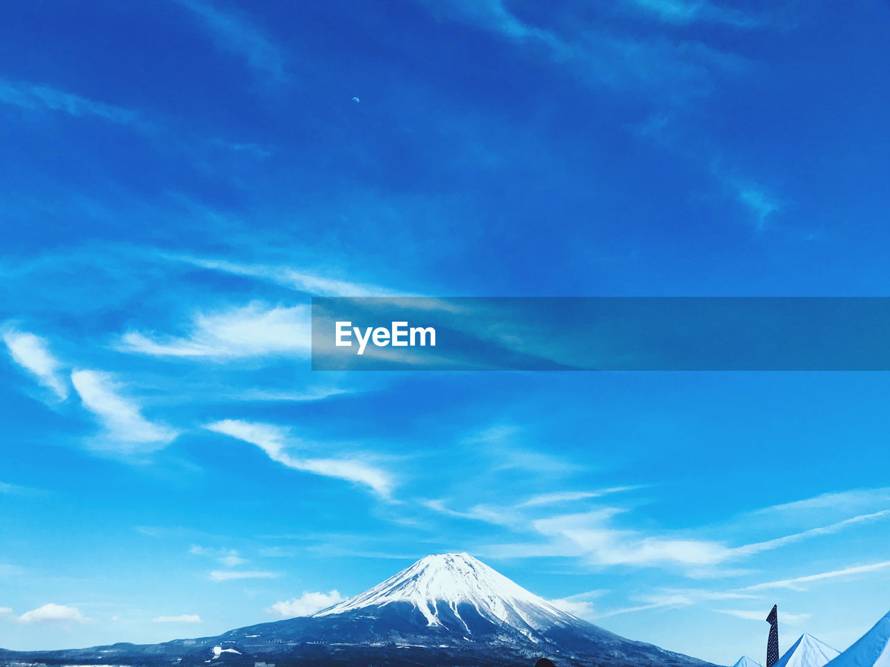 Scenic view of snowcapped mountains against blue sky