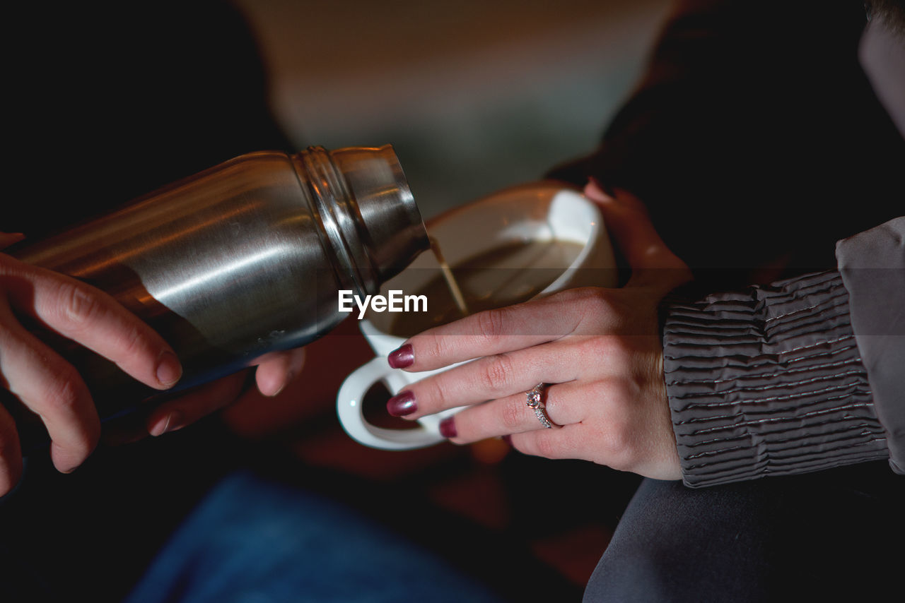 Midsection of couple having coffee at home