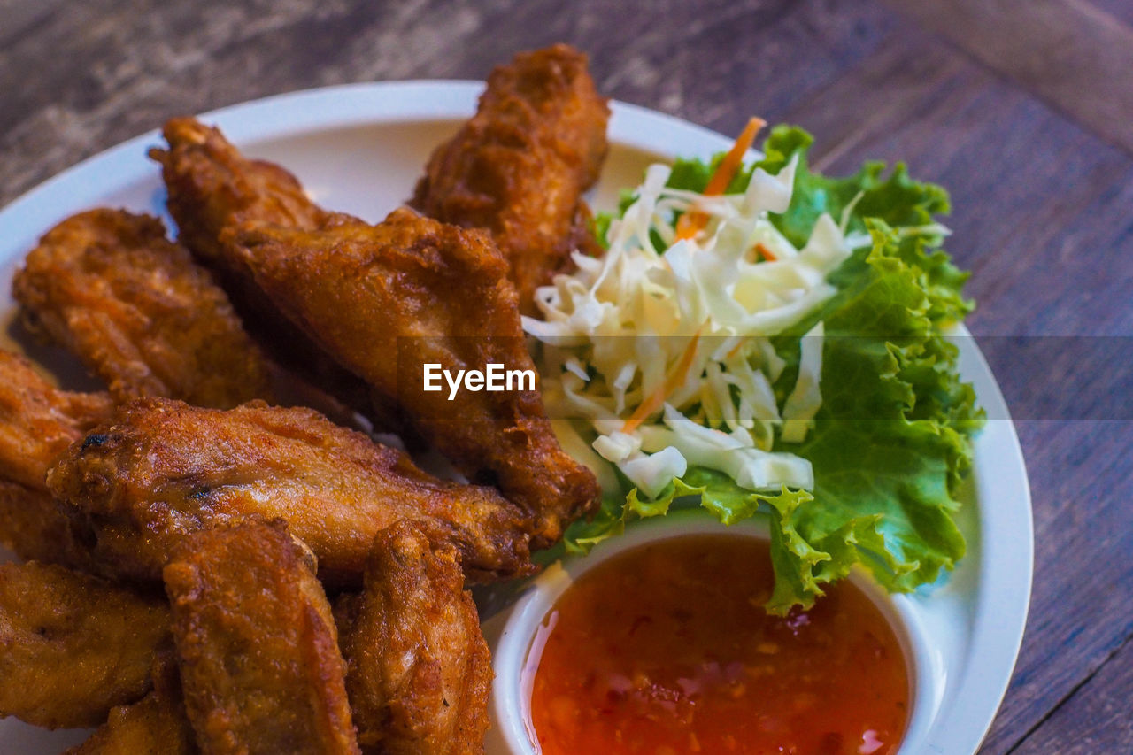 Fried chicken wings with vegetable on white plate delicious food still life.