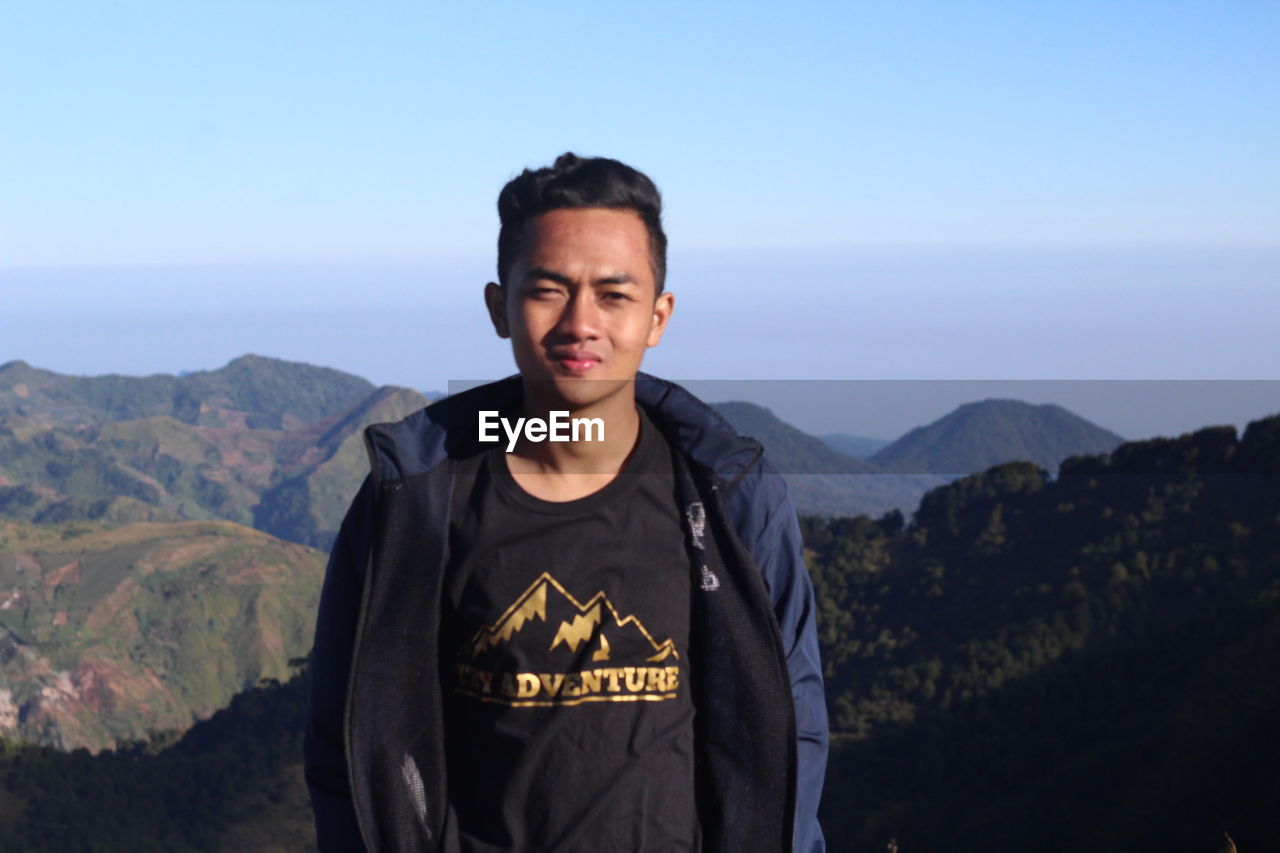 Portrait of man standing against mountains