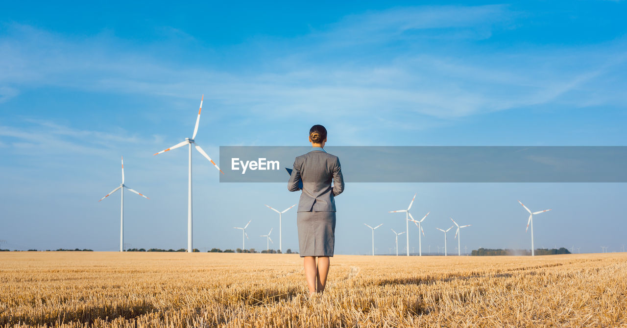 Woman standing on field against sky