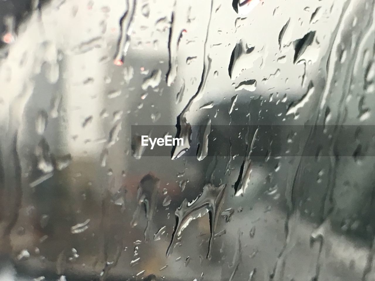 FULL FRAME SHOT OF WET GLASS WINDOW IN RAIN