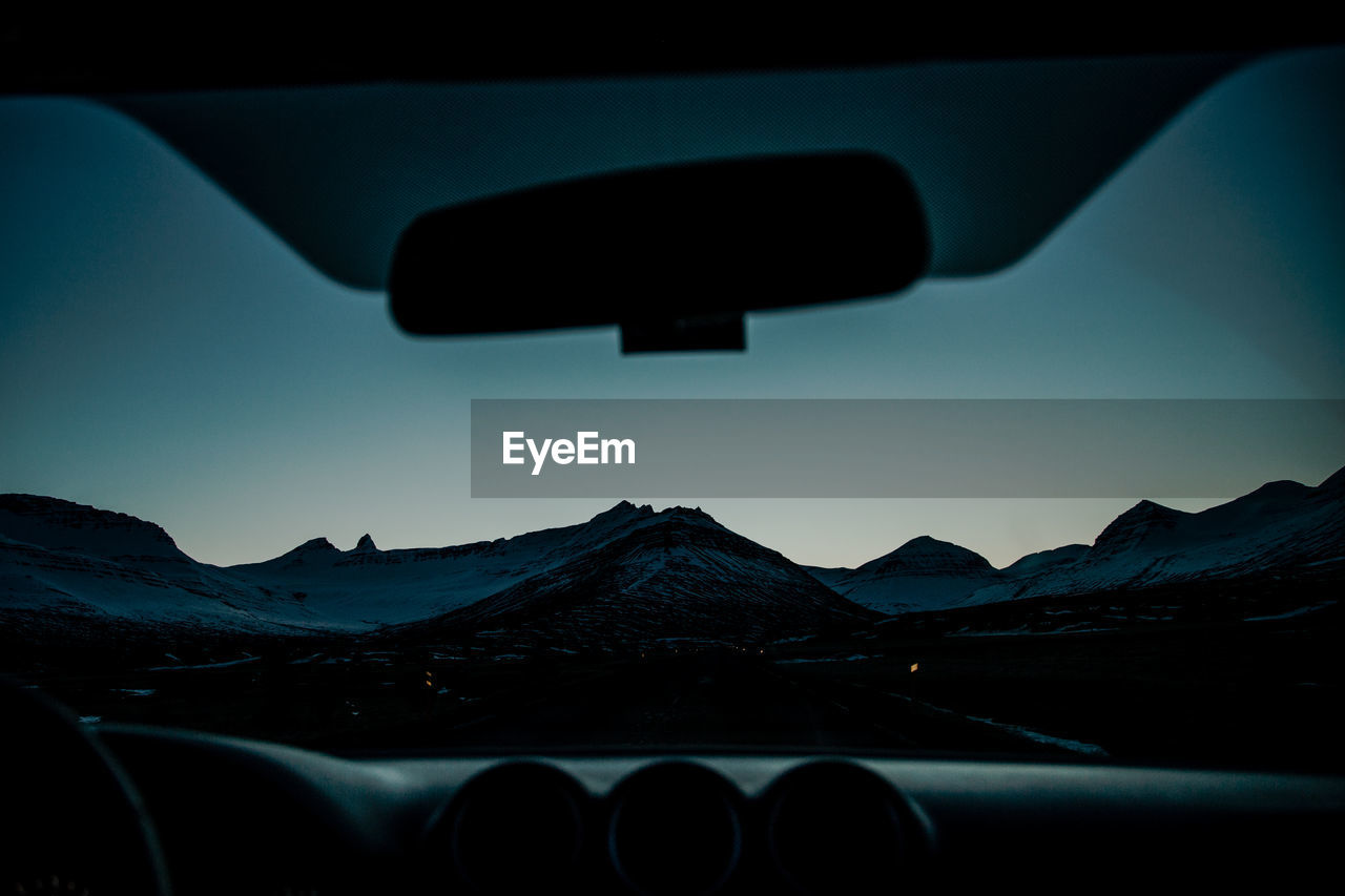 Scenic view of mountains seen through car windshield