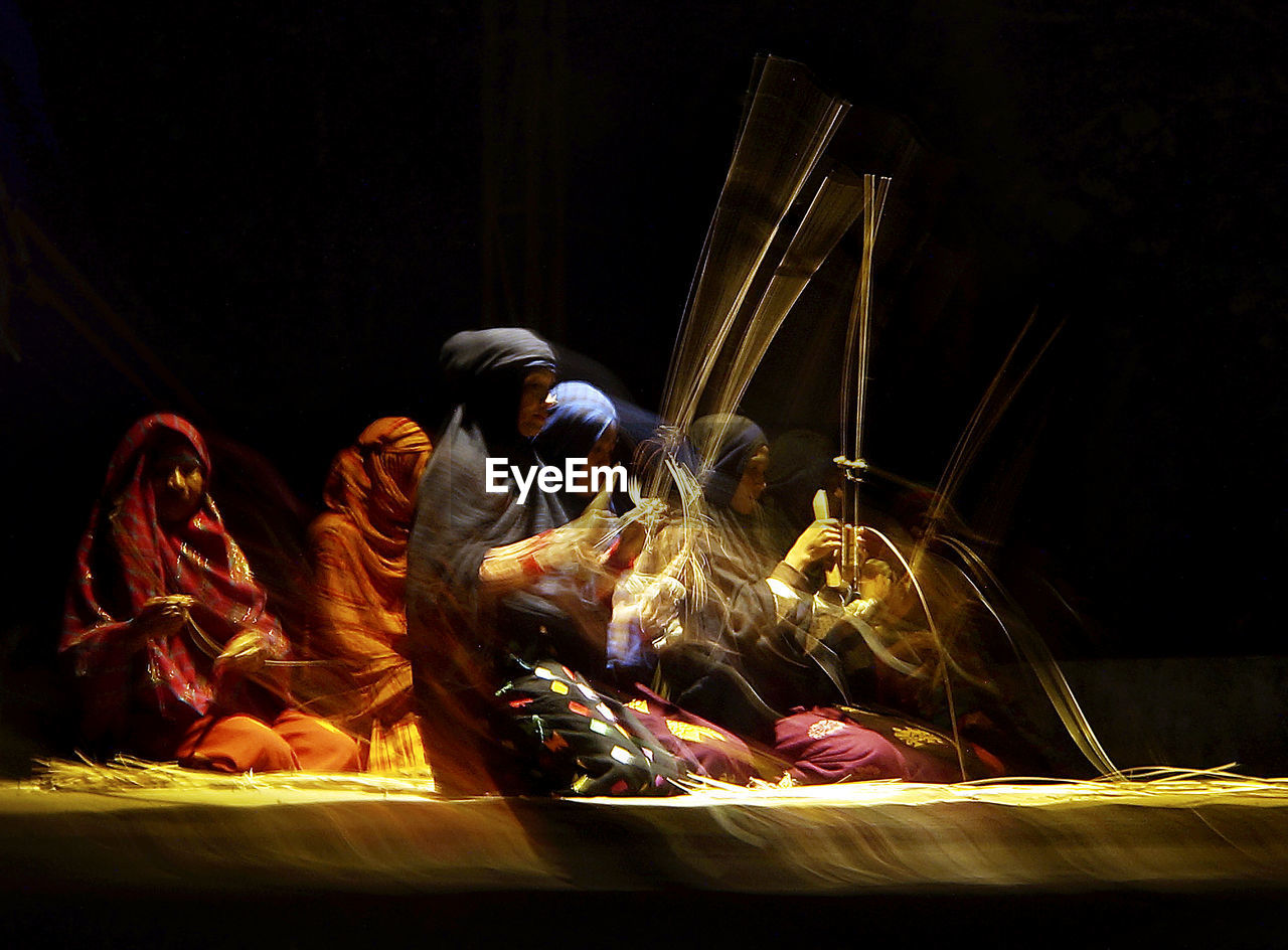 PEOPLE WORKING ON ILLUMINATED STAGE