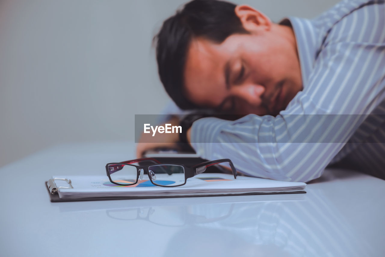 Tired businessman napping on desk in office