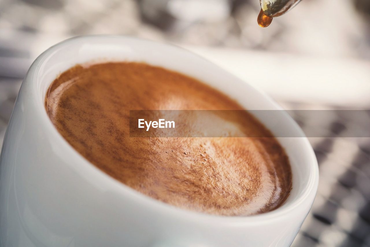 CLOSE-UP OF CUP OF COFFEE IN CAFE