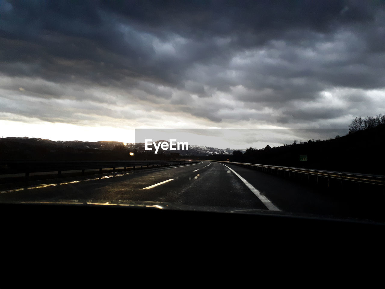 HIGHWAY AGAINST SKY SEEN FROM CAR